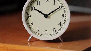 Beyaz Mekanik Analog Alarm Saati 'nin Karanlık Arkaplanda Eğik Kamera Hareketi