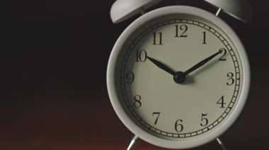 Panning Camera Shot of Mechanical Analog Alarm Clock on Dark Background