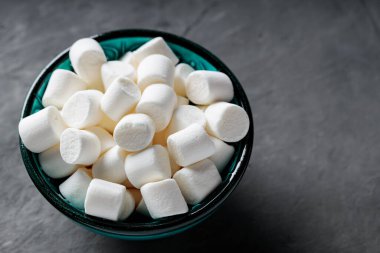 Gri Beton Yüzeyde Turkuaz Kasede Beyaz Şekerlemeler