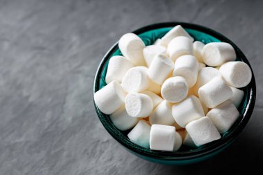 Gri Beton Yüzeyde Turkuaz Kasede Beyaz Şekerlemeler