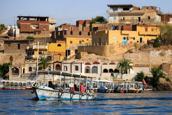 Bir tekne, Mısır 'ın Aswan kentindeki İsis tapınağına ziyaretçileri Nil' den taşıyor.