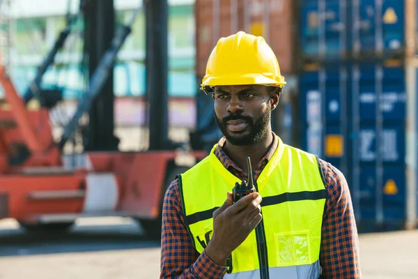 stock image Logistics industry African black male engineer staff worker foreman at port container yard control loading cargo