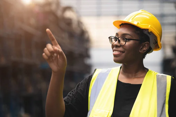 工場倉庫の黒いアフリカのスマート女性エンジニアの指ポイントカウント株式誇りに思って笑顔 — ストック写真