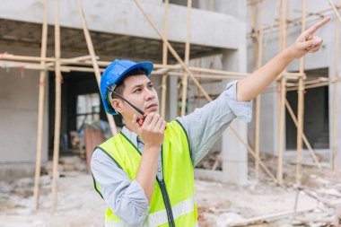 Ustabaşı mühendis erkek işçi inşaat sahasında ev inşaatı projesinde sıkı çalışma niyetinde.