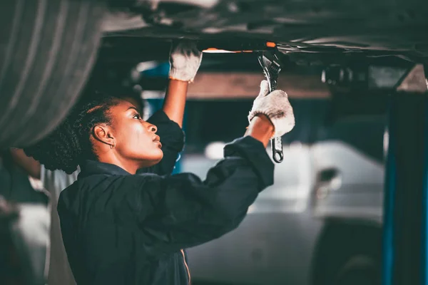 Garage women worker mechanic team working car auto service fix replace  under car lift hoist