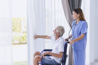 Nurse care elderly senior old man at home retirement people recovery on wheelchair.