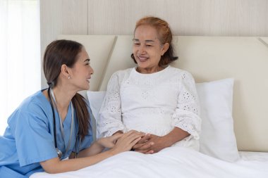 Nurse take care patient elderly senior woman talking consolation recovery on bed at home
