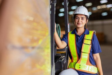 Indian woman staff worker engineer supervisor in safety suit work in factory warehouse