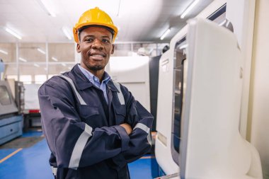 Modern metal fabrikasında Cnc torna makinesinde çalışan akıllı Afrikalı erkek mühendis portresi