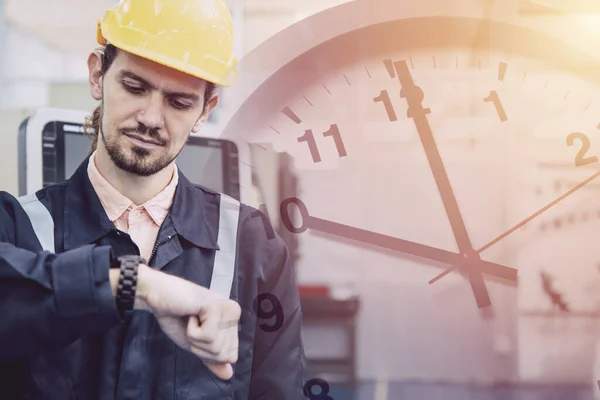 Engineer worker worry looking at wristwatch overlay time clock face. Industry factory late working hours concept.