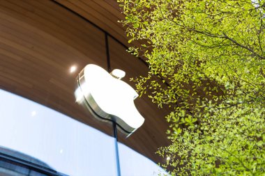 Apple mağazasının dış cephesinde çevre dostu olarak yeşil ağaçla birlikte elmalı iş logosu tabelası. Bangkok, THAILAND - Mart 04: 23.