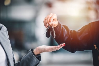 Yakındaki erkek, araç kredisi, kiralama ya da kiralama konsepti için araba anahtarı veriyor