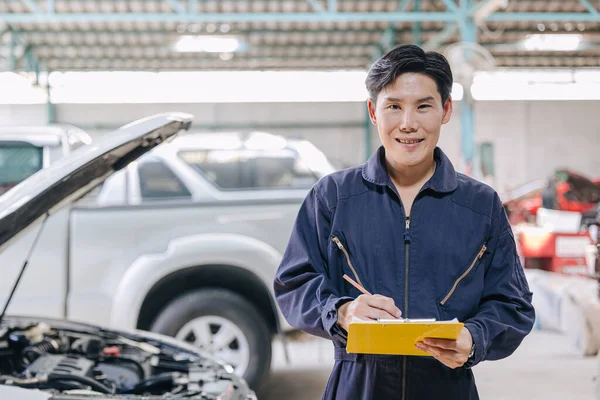 portrait mechanic engineer male happy for service fix repair broken car in garage auto shop. car insurance claim cost estimate team.