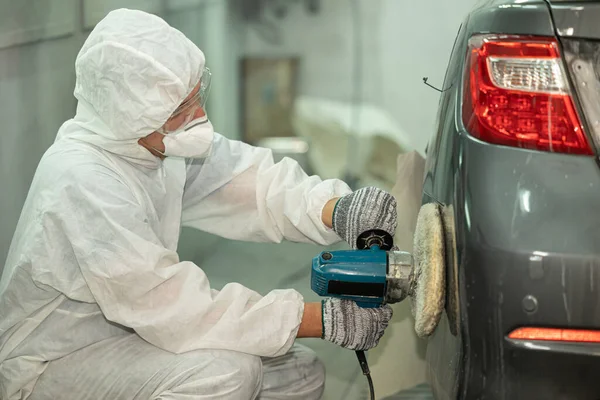 Garage car color repair wax coat and glossy polishing team staff working in auto workshop