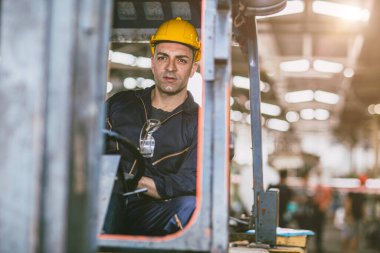 Forklift şoförü erkek depo çalışanı lojistik fabrikası kargo depolama merkezinde çalışıyor..