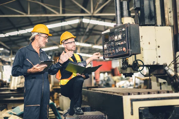 シニア男性労働者訓練重工業金属工場で働く新しい若いエンジニアの従業員 — ストック写真