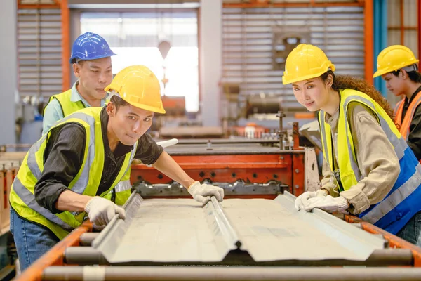金属板金工場で働くアジア人労働者はチームワークとして一緒に働くのを助ける — ストック写真