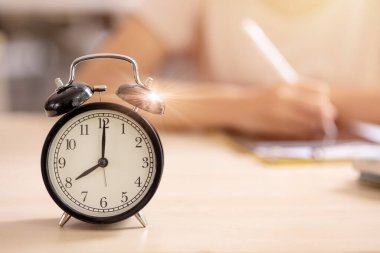 Eğitim alarmı çarpı saat okul öğrencisi sabah bulanık arkaplanda yazmayı öğreniyor..