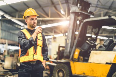 Engineer foreman using walkie talkie radio operate control loading cargo in warehouse portrait confident clipart