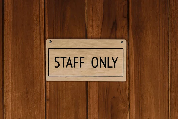 stock image STAFF ONLY wood text badge sign banner on wooden door panel background.