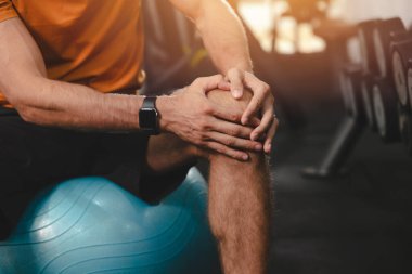 Yakın plan erkek el ele tutuşup diz sakatlığı geçiriyor. spor erkek ağrıları diz kapağı ya da diz kapağı bağları ağrısından muzdarip.