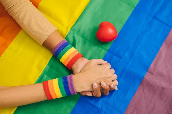 Lgbtトランスジェンダーの女性の手は セクシュアリティの権利運動の人々の背景のための愛の心を持つ虹の旗で一緒にサポートを保持 — ストック写真