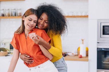 LGBT aşığı kadınlar dans ediyorlar evde romantik mutluluğa sarılıyorlar. homoseksüel kadın çok ırklı siyah beyaz kız birlikte..