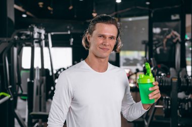 Süt sıkacağı şişeli sağlıklı bir sporcu. Kas gücünü artıran süt proteini içmekten mutluluk duyarız. Spor salonunda az yağlı içecek yeriz.