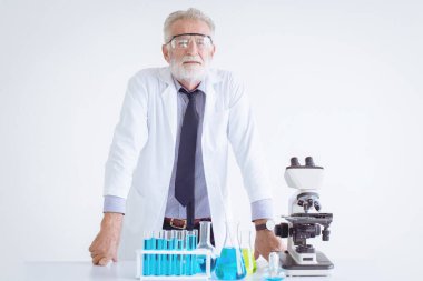 Kimya bilimi kucağında mikroskopla duran kıdemli yaşlı kimyager Doktor.