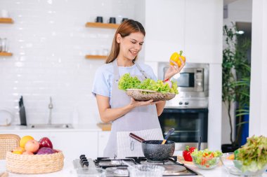 Salata yapan mutlu genç kadın. Sağlıklı yemek yiyen insanlar. Mutfakta Vejetaryen Kadın. Diyet için sebze ye. Ada Fırınında Diyet Yemeği Hazırla.