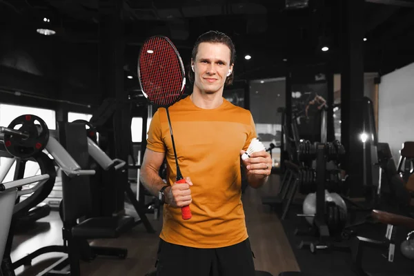 ラケットと羽根のシャトル付きのスマートプロバドミントン選手ジムスポーツクラブ筋肉フィットネストレーニングで立っている肖像画 — ストック写真