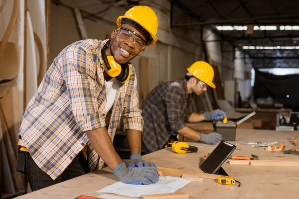 stock image African male happy worker wood furniture maker staff, wood panel construction site work men team.