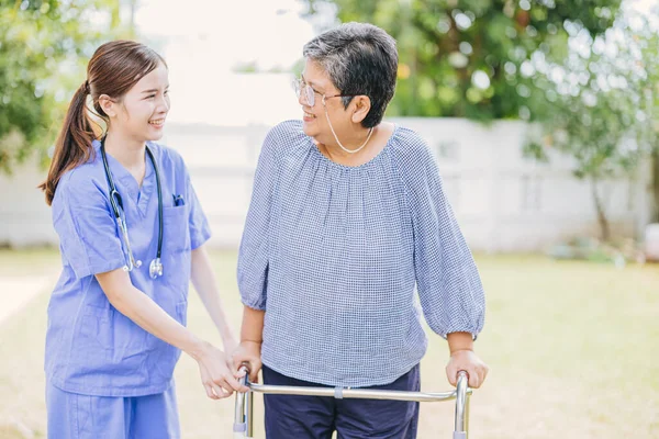 Молода Медсестра Допомагає Азіатській Старшій Жінці Ходити Доглядальниця Яка Допомагає — стокове фото