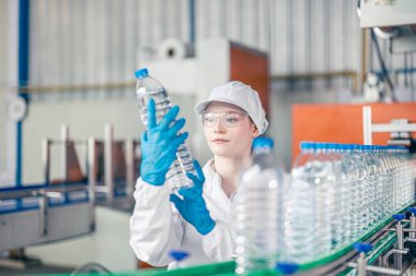 İçme suyu fabrikasında çalışan bir işçi. Kadın işçiler, beyaz işçiler, temiz üretim bandı, maden suyu fabrikası..