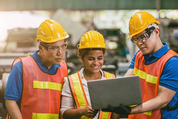 工程师女工和男工一起在工厂里一起工作看着笔记本电脑开心的微笑 — 图库照片