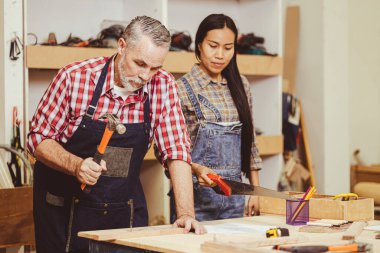 Üst düzey Kafkas erkek ahşap döşeme atölye eşinin mobilyalarını tamir etmek için çalışıyor..