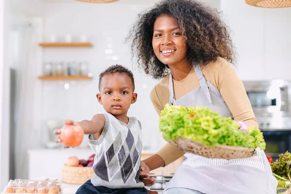 African black mother with cute son child portrait happy enjoy healthy food cooking at home kitchen holiday activity