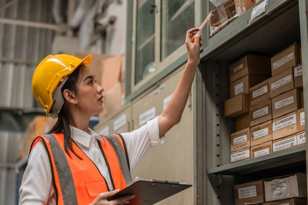 若いエンジニア女性スタッフ従業員工場のハードウェア倉庫で働く従業員作業チェック製品カウント在庫部品ロットリスト — ストック写真