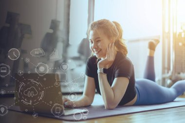 Spor salonunda gülümseyen spor salonundaki bayan rahatlıyor. Bilgisayarı izleyen sağlıklı genç bir kadın..