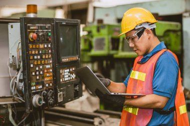 Mühendis işçi kontrol paneli programı CNC torna makinesini çalıştırmak dizüstü bilgisayar tamir eski makine.