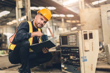 Portre mühendisi erkek işçi takvim makinesi servis kontrolü. Müfettişler güvenlik için ağır sektörde çalışıyorlar.