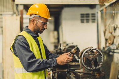 Latin Hintli erkek profesyonel teknisyen metal fabrikasında çelik hassas değirmen makinesi ile çalışıyor.