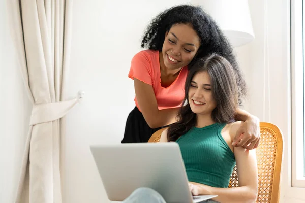 LGBTQ transgender women together at home enjoy using laptop computer together happy smiling