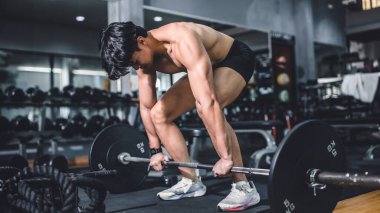 Spor salonu ağırlık kaldırma, ağırlık kaldırma, Asyalı vücut geliştirme, ev içi spor klubü. Vücut geliştirici halter kaldırma egzersizini ağır çubukla yapıyor..