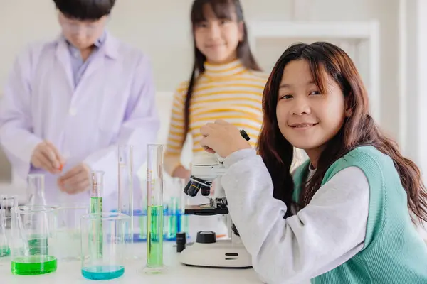 Portrait smart young asian teen girl enjoy learning and play in school experimental chemical science lab  happy smiling