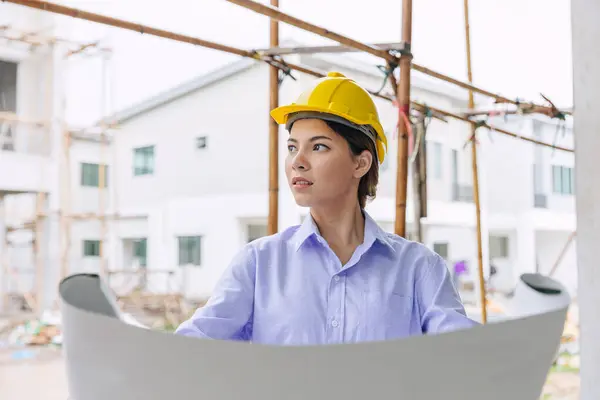 Smart woman engineer worker builder worker in construction site. Architect home project chief designer officer with building floor plan.
