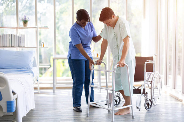 Восстановление мышц пациента ходьба тренировки с помощью ходунков с физиотерапевтом помощи поддержки