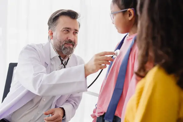 stock image Mother with daughter meeting pediatrician doctor at the clinic for health check talking about mental problems.