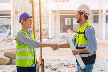 İnşaatçı işçi toplantı proje yöneticisi mühendis ekip lideri ile başarılı iş anlaşması ekip çalışması için el sıkışıyor