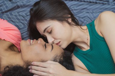 İki kadın aşığı LGBT birlikte yaşıyorlar. Yatakta öpüşüyorlar.